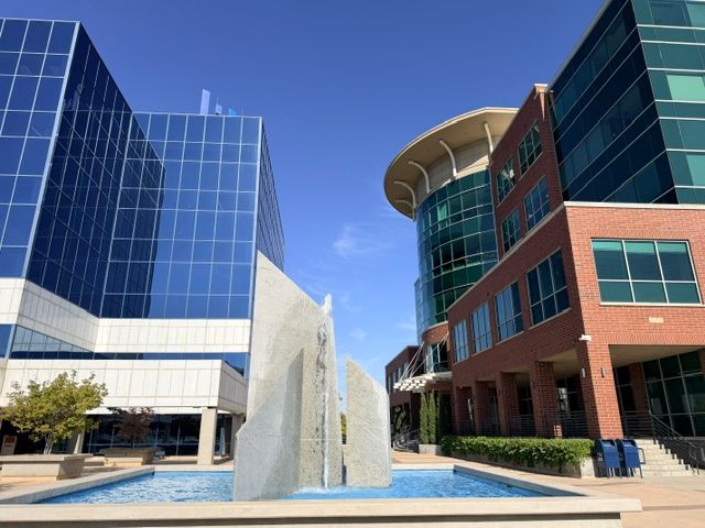 The Parkview Plaza campus — the mirrored-glass tower at 2180 alongside the brick and glass building at 2150, with the plaza fountain between them.